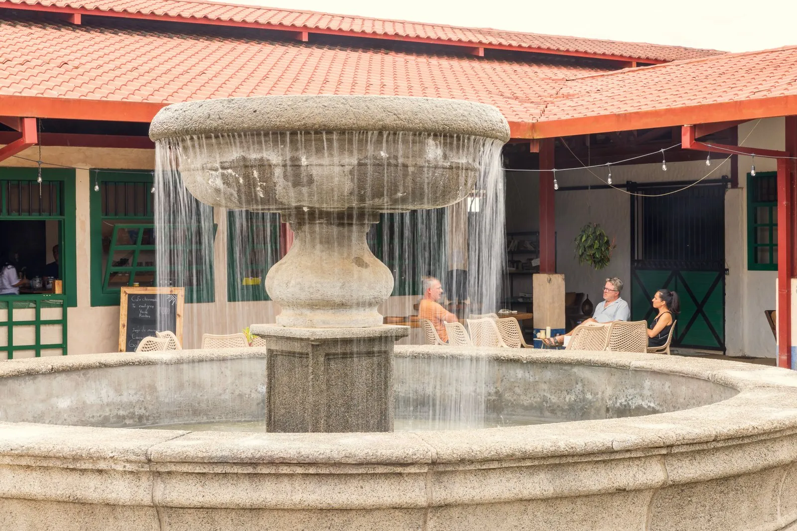 Stone fountain with community members gathering in the Town Square courtyard